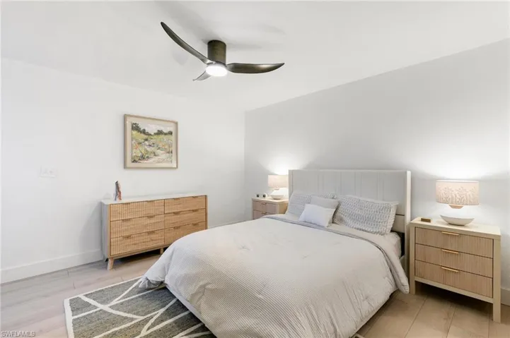 Bedroom featuring light wood-style floors, baseboards, and a ceiling fan