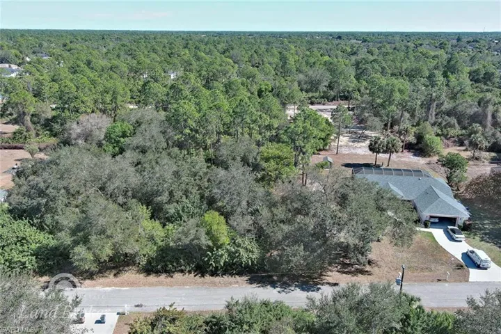 Aerial view of property's location with a heavily wooded area