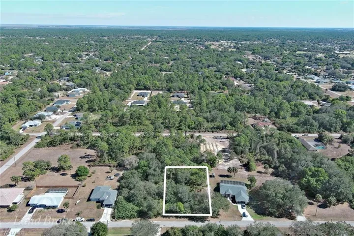Aerial overview of property's location featuring property parcel outlined and a heavily wooded area