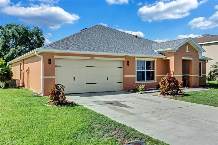 Orange stucco exterior with white trim accents and a gray shingle roof