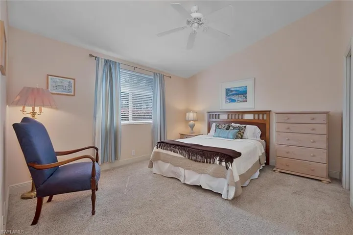 Bedroom featuring light carpet, lofted ceiling, and ceiling fan