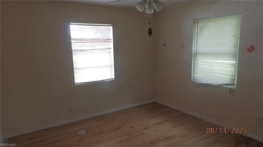 Empty room featuring light wood-type flooring and a ceiling fan
