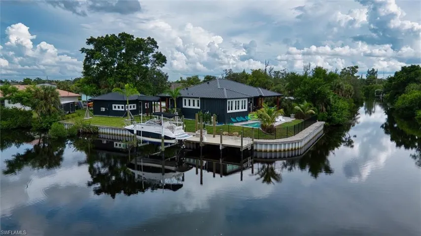 Waterfront residence featuring a private boat dock, pool, and expansive water frontage