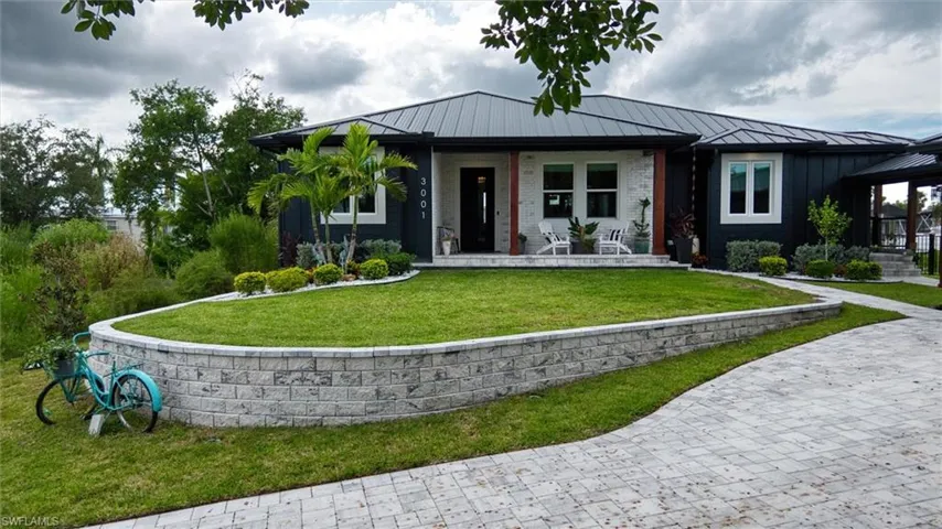 Contemporary exterior featuring dark horizontal siding, white brick accents, and a dark metal roof