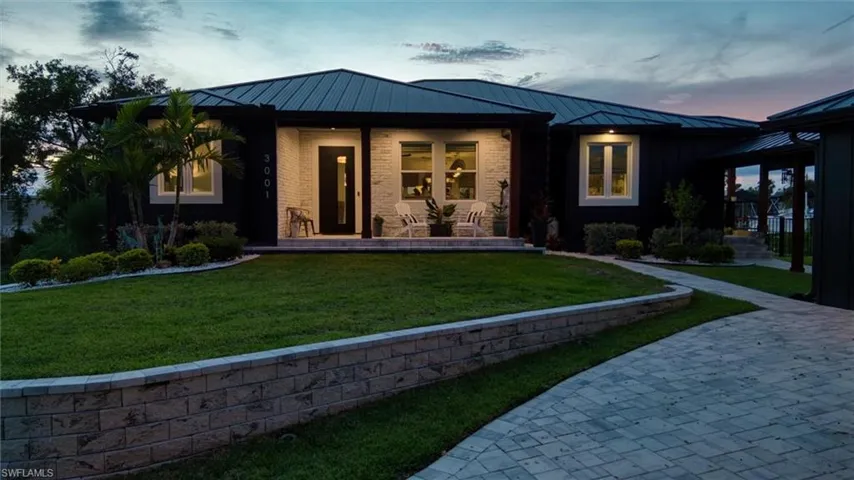 Modern exterior featuring a dark facade with light-colored stone accents