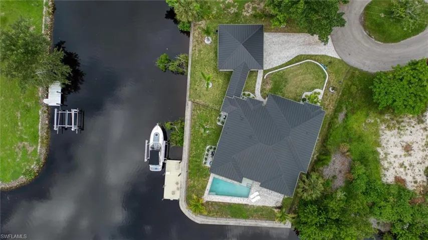 Waterfront property featuring a private boat dock, boat lift, and inground swimming pool