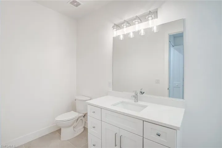 Half bath featuring vanity and tile patterned floors
