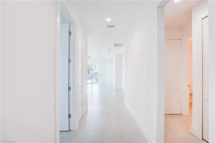 Hallway with recessed lighting and baseboards