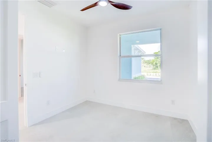 Spare room with ceiling fan and baseboards