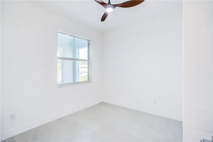 Empty room with baseboards and a ceiling fan