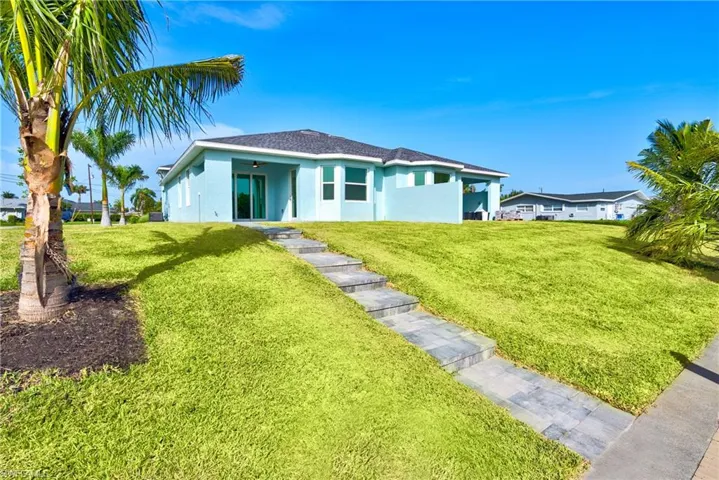 Rear view of property with ceiling fan, a yard, stucco siding, and a shingled roof