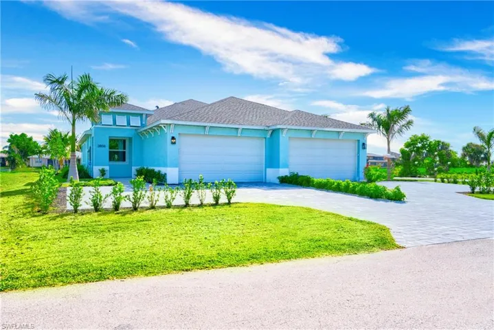 View of front of house with decorative driveway, a garage, a front yard, and stucco siding