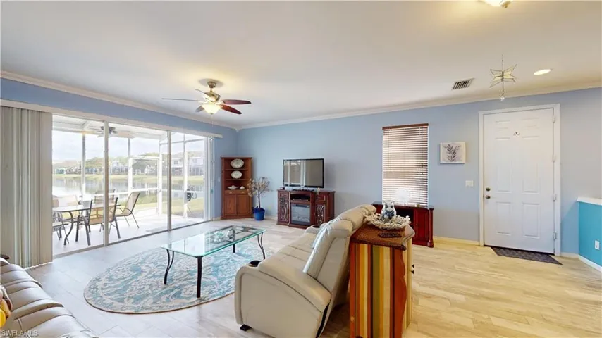 Living room featuring light hardwood / wood-style flooring, ceiling fan, and crown molding