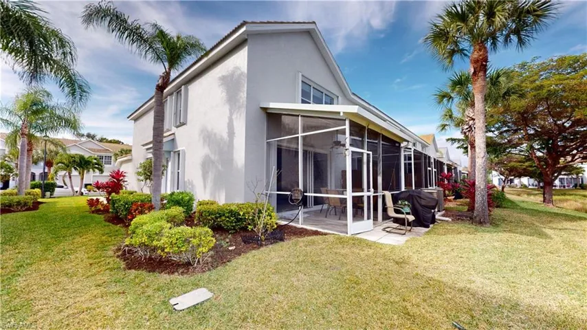 Rear view of property with a sunroom and a lawn