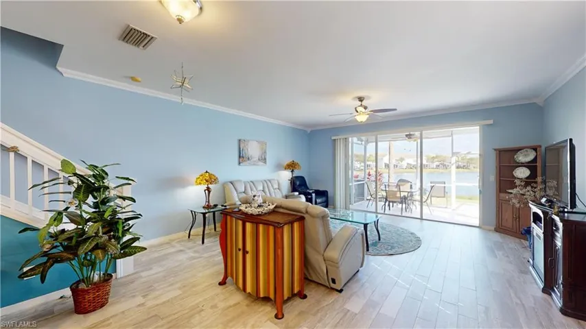 Living room featuring crown molding, light wood-type flooring, and ceiling fan