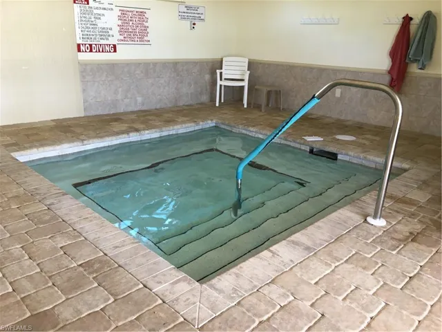 View of swimming pool featuring an indoor hot tub