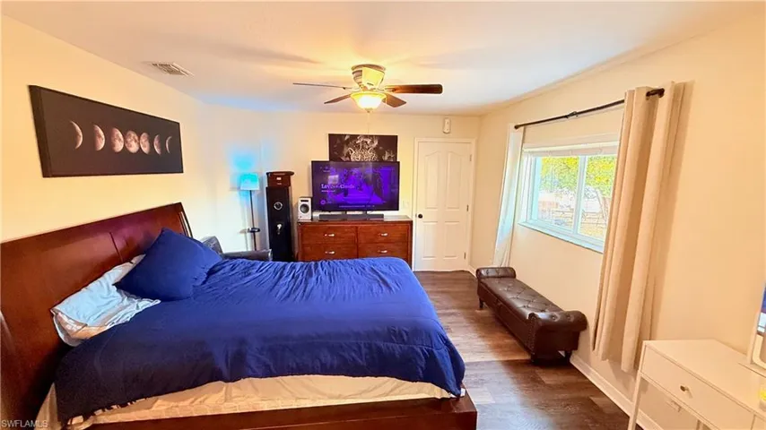Bedroom with dark wood-style flooring and a ceiling fan
