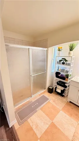 Bathroom featuring vanity and shower / bath combination with glass door