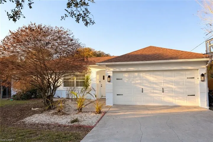 View of front of property featuring driveway, an attached garage, and stucco siding