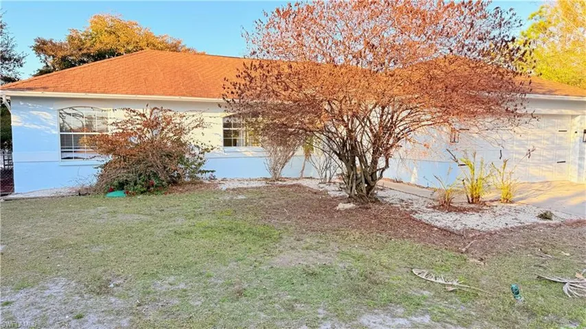 View of front of house with a front lawn and stucco siding