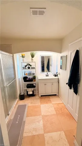 Full bathroom featuring a stall shower, vanity, and a textured ceiling