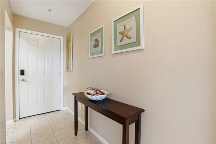 Doorway to outside featuring tile patterned floors and baseboards