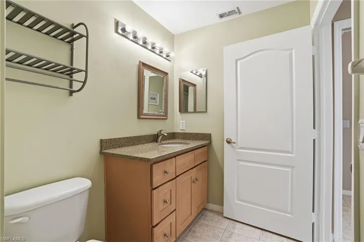 Half bath featuring vanity and light tile patterned floors