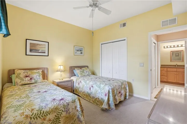 Carpeted bedroom with a closet and a ceiling fan
