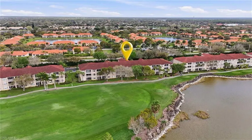 Aerial view of property's location featuring a nearby body of water and a golf course