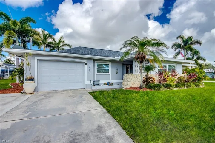 Ranch-style home featuring a garage and a front yard