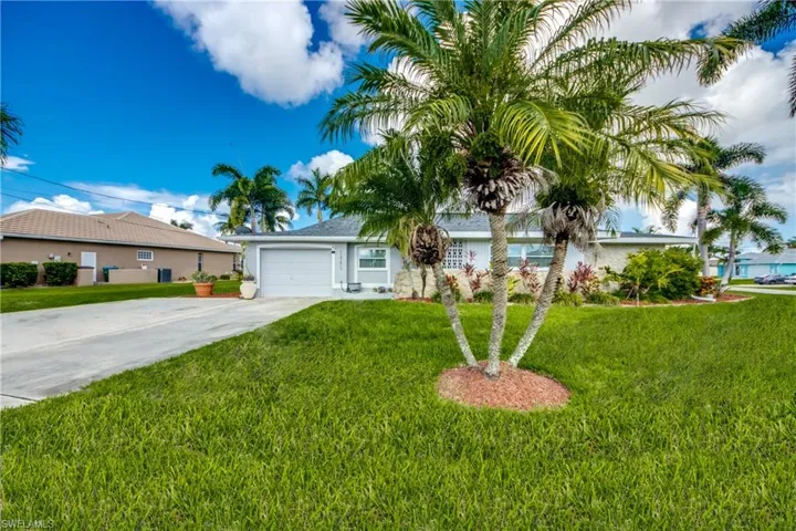 Single story home featuring a garage and a front lawn