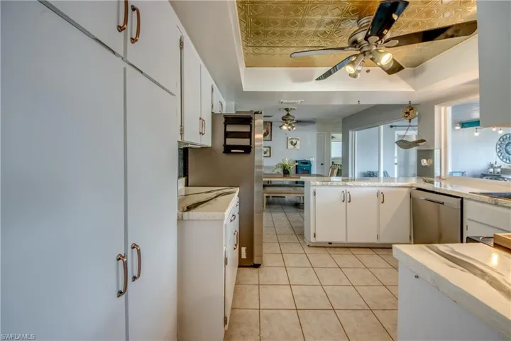 Kitchen with white cabinets, stainless steel dishwasher, and a raised ceiling