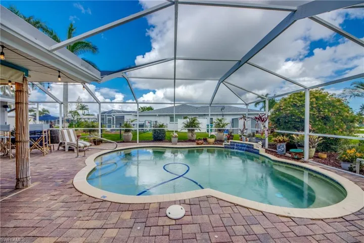 View of swimming pool with water feature and swim up table