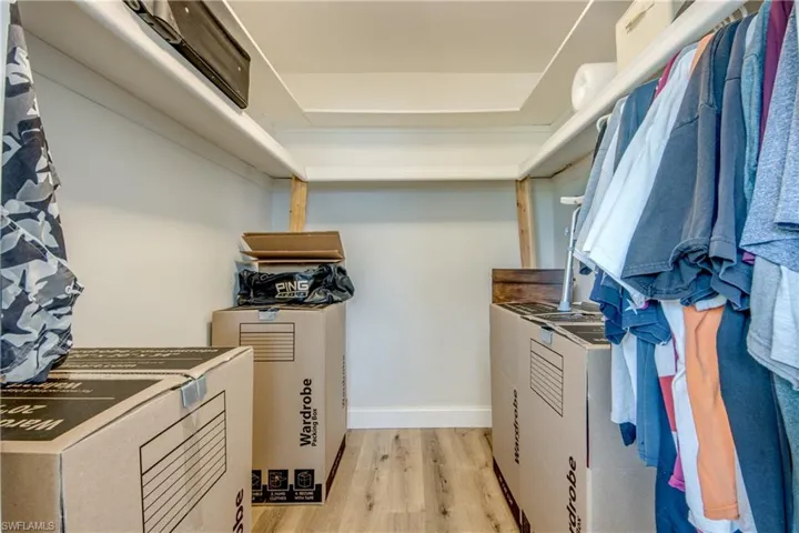 Spacious closet with washer / clothes dryer and light wood-type flooring