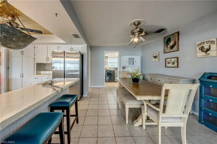 Tiled dining area with ceiling fan and a tray ceiling