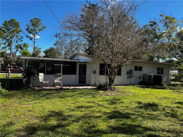 Back of house with a lawn and a sunroom