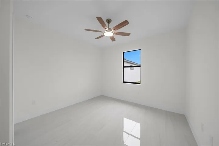 Recessed lighting with a ceiling fan, light-toned walls, and large format tile flooring