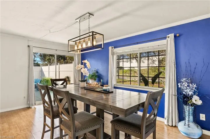 Dining area featuring plenty of natural light, a chandelier, light wood-type flooring, and ornamental molding