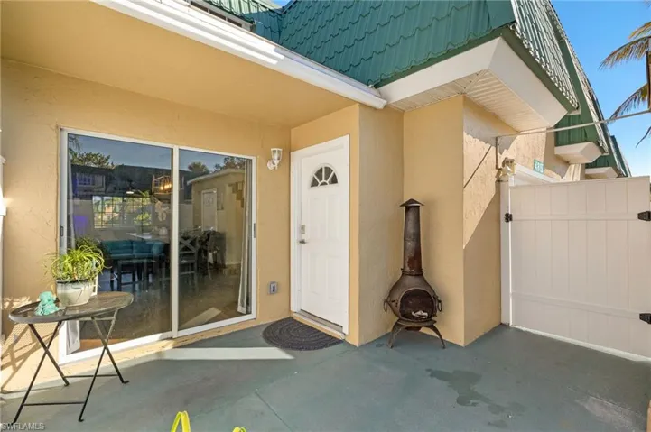 View of exterior entry with stucco siding and a patio area
