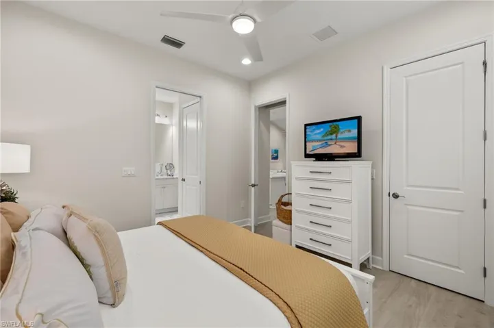 Bedroom featuring ensuite bathroom, ceiling fan, and light hardwood / wood-style floors