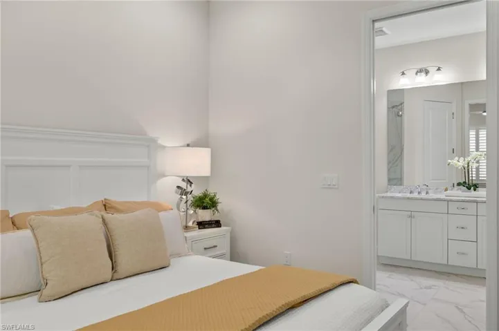 Bedroom with connected bathroom, sink, and light tile patterned floors