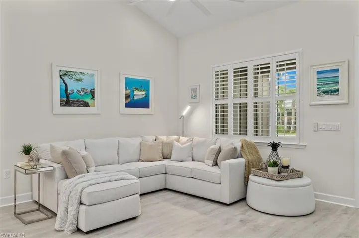 Living room with light hardwood / wood-style flooring, high vaulted ceiling, and ceiling fan