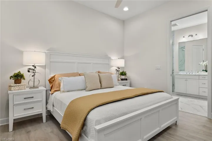 Bedroom featuring light hardwood / wood-style flooring, ensuite bathroom, sink, and ceiling fan