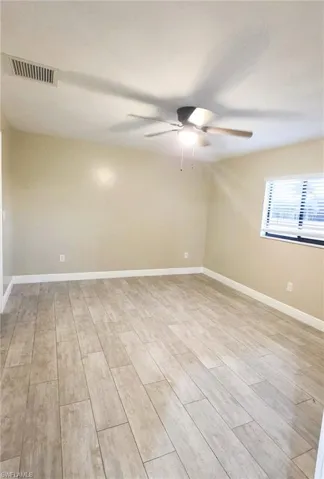 Spare room with wood finish floors and ceiling fan