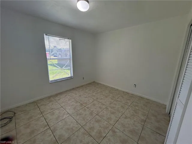 Unfurnished bedroom with light tile patterned floors and a closet