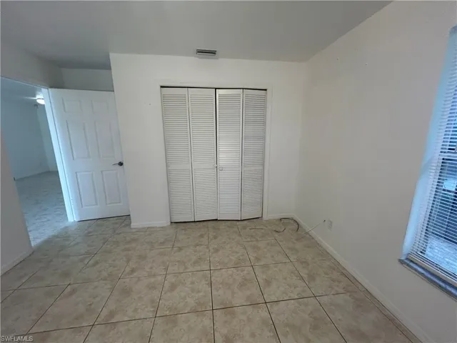 Unfurnished bedroom with light tile patterned floors and a closet