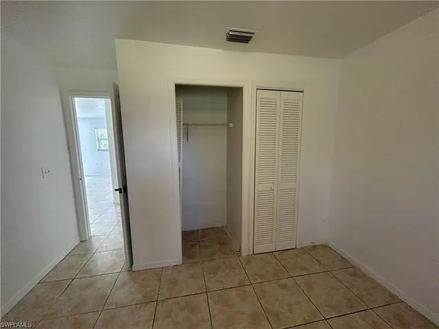 Unfurnished bedroom featuring a closet and light tile patterned floors