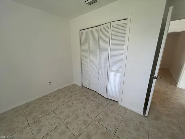 Unfurnished bedroom featuring a closet and light tile patterned flooring