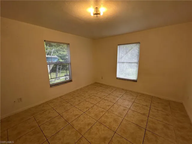 Empty room with baseboards and light tile patterned floors