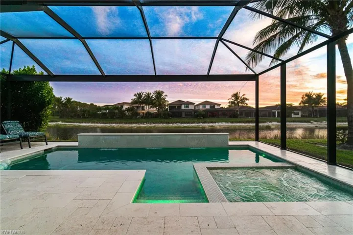 Stunning sunset and lake views from the screened lanai featuring a custom pool and connected spa.